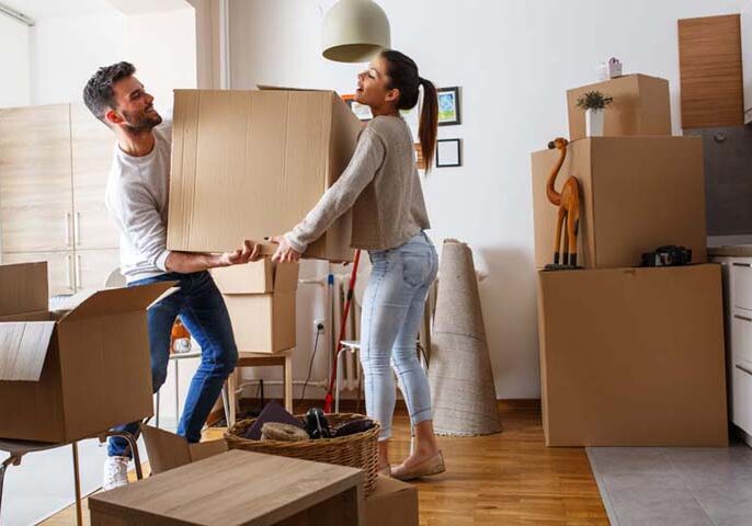 Young couple carrying big cardboard box at new home.Moving house Young couple carrying big cardboard box at new home.Moving house